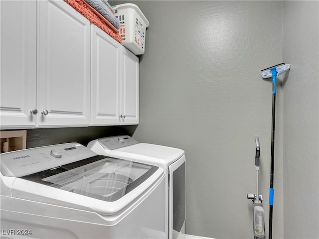 laundry area featuring washer and clothes dryer and cabinets