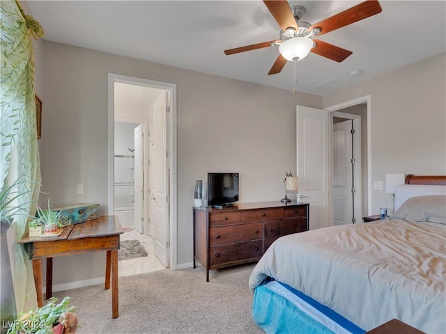 bedroom with ensuite bathroom, ceiling fan, and light carpet