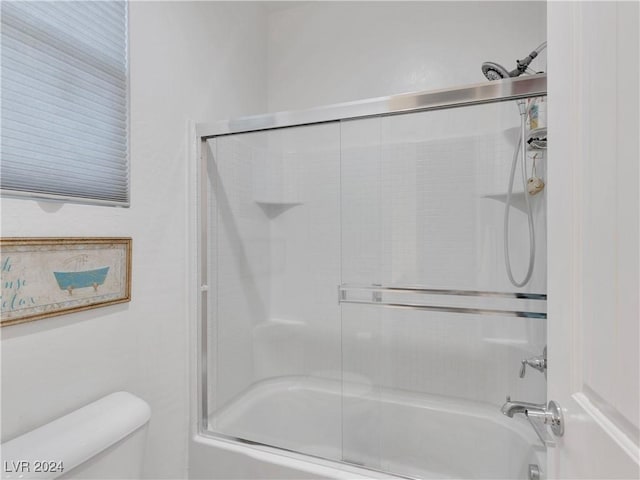 bathroom featuring shower / bath combination with glass door and toilet