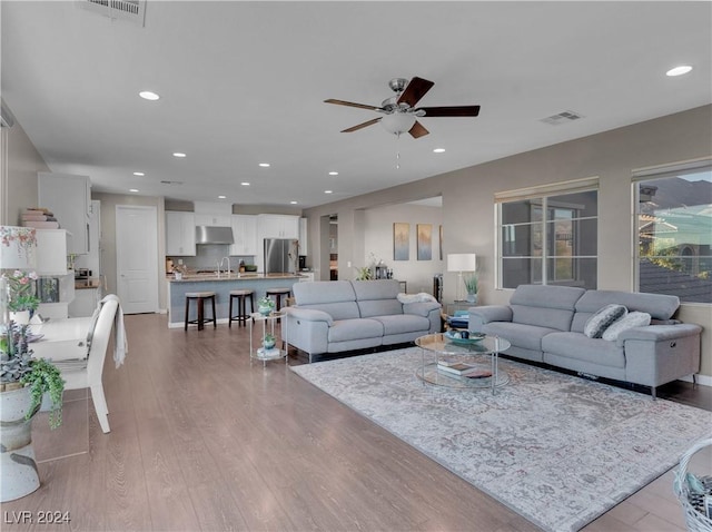 living room with ceiling fan and light hardwood / wood-style floors