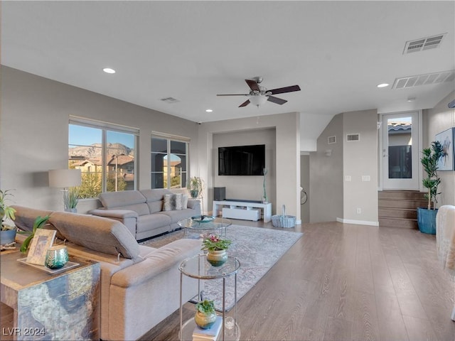 living room featuring wood-type flooring and ceiling fan