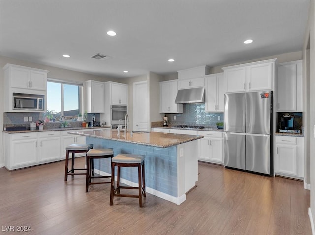 kitchen featuring white cabinets, light wood-type flooring, and stainless steel appliances