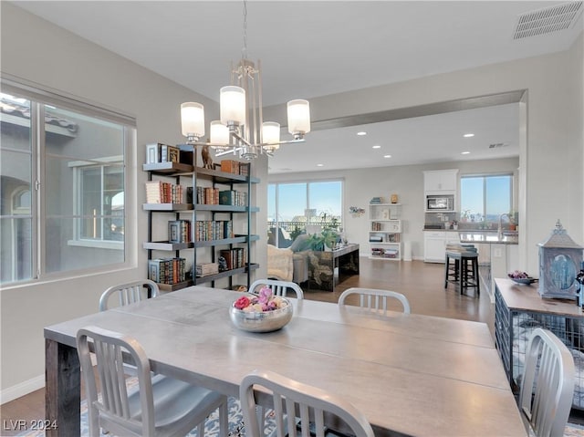 dining area featuring hardwood / wood-style floors, sink, and a chandelier