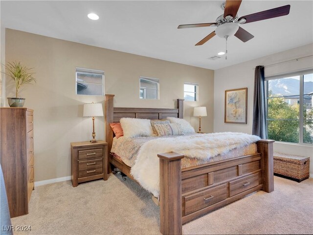 carpeted bedroom featuring multiple windows and ceiling fan