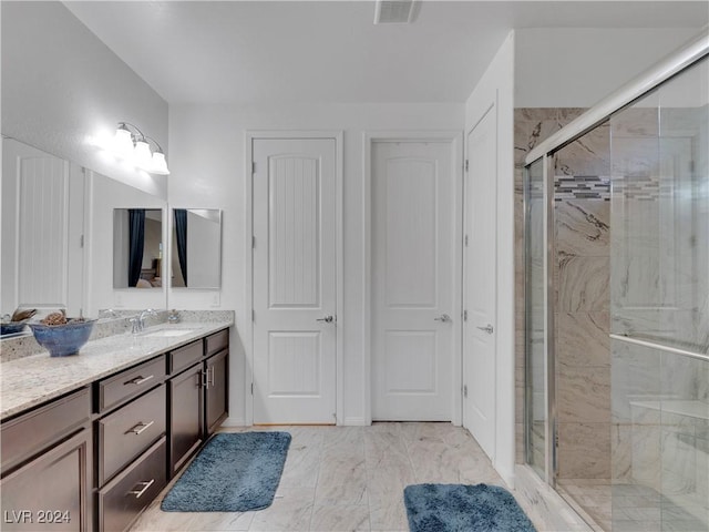 bathroom featuring vanity and a shower with door