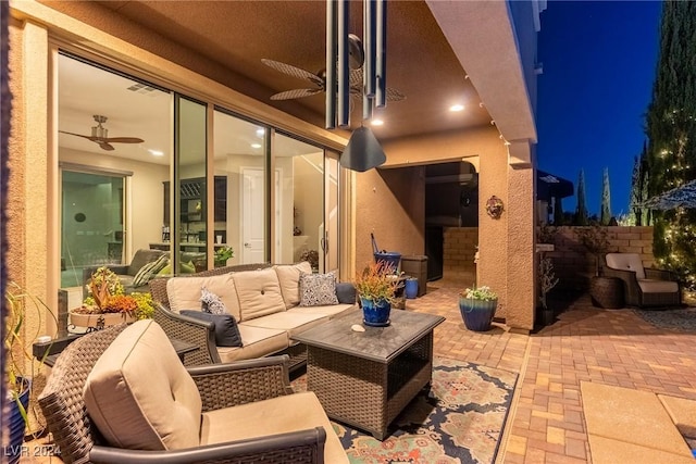 patio at twilight with ceiling fan and an outdoor hangout area