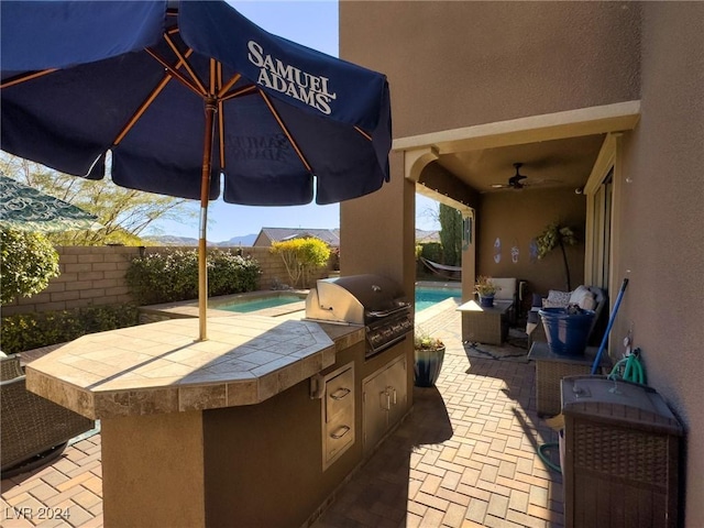 view of patio featuring area for grilling and ceiling fan