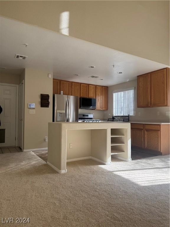 kitchen featuring light carpet, a breakfast bar area, and stainless steel appliances