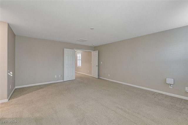 unfurnished room featuring light carpet