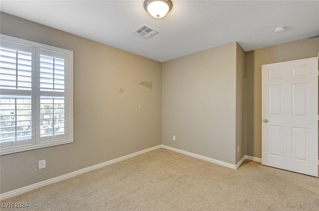 spare room featuring light carpet