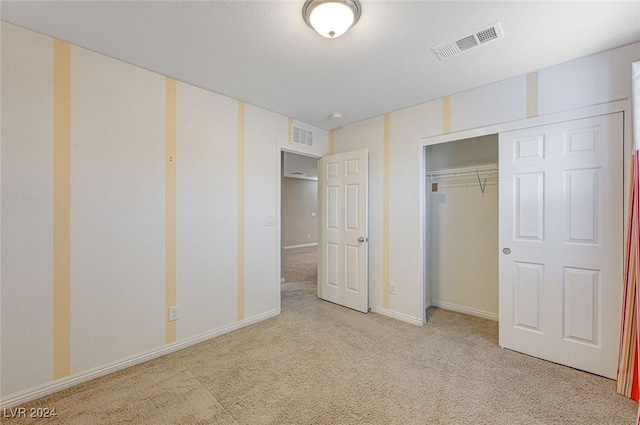 unfurnished bedroom with light carpet and a closet