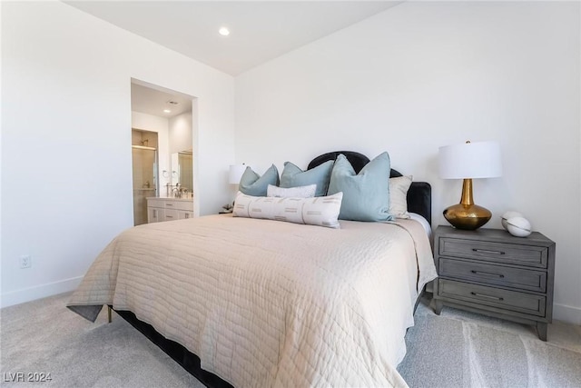 bedroom featuring connected bathroom and light colored carpet