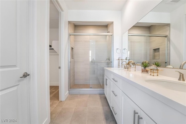 bathroom featuring vanity, tile patterned floors, and a shower with shower door