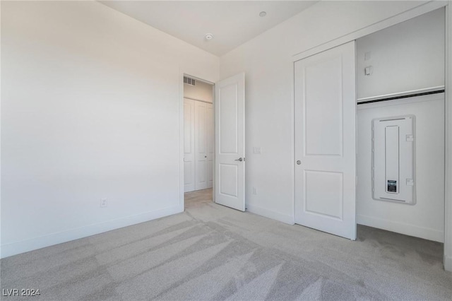 unfurnished bedroom with light colored carpet and a closet