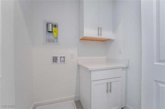 clothes washing area featuring washer hookup and cabinets