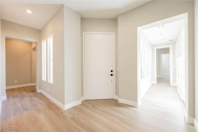 corridor with light hardwood / wood-style flooring and plenty of natural light