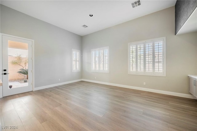 spare room with plenty of natural light and light hardwood / wood-style floors