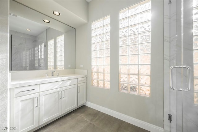 bathroom with vanity and a shower with door