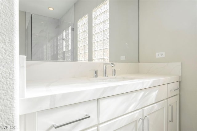 bathroom with vanity and a shower with shower door