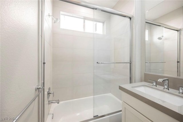 bathroom featuring vanity and bath / shower combo with glass door