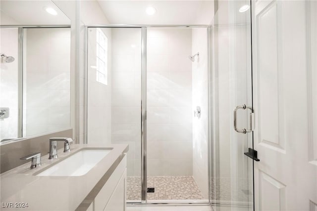 bathroom featuring vanity and a shower with door