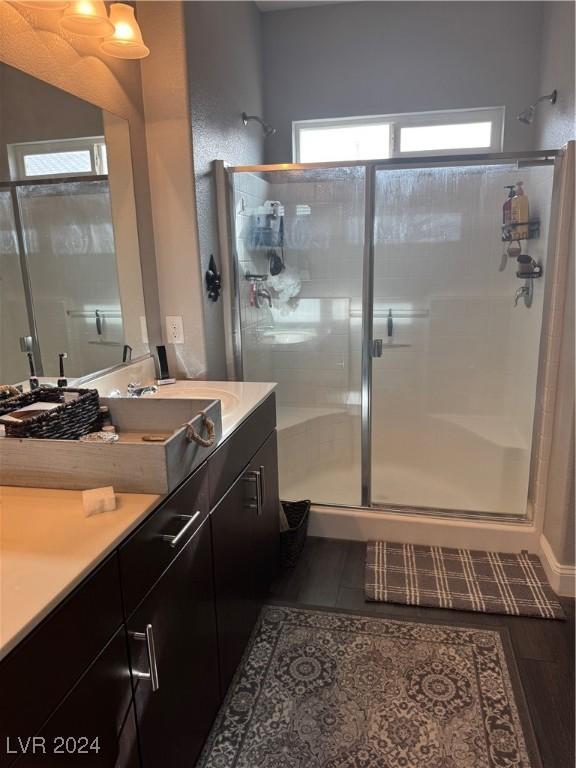 bathroom featuring a wealth of natural light, walk in shower, and vanity