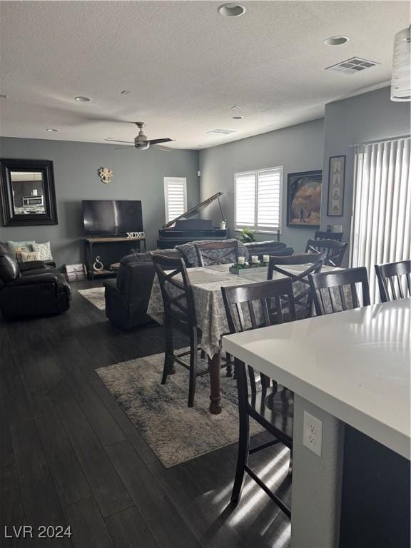 dining space with hardwood / wood-style flooring, a textured ceiling, and ceiling fan