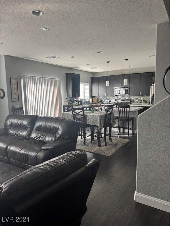 living room featuring a textured ceiling and dark hardwood / wood-style flooring