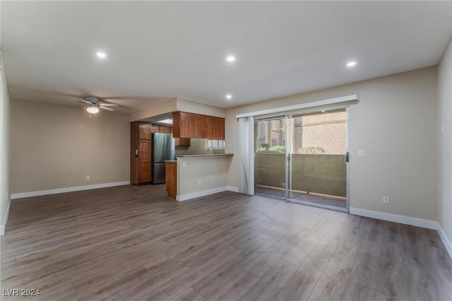 unfurnished living room featuring wood-type flooring and ceiling fan