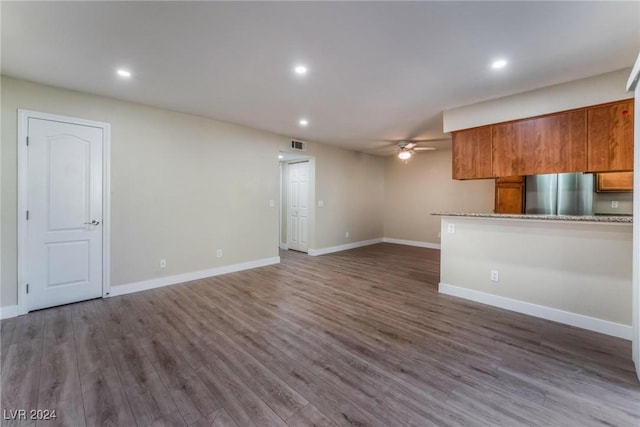 unfurnished living room with dark hardwood / wood-style flooring and ceiling fan