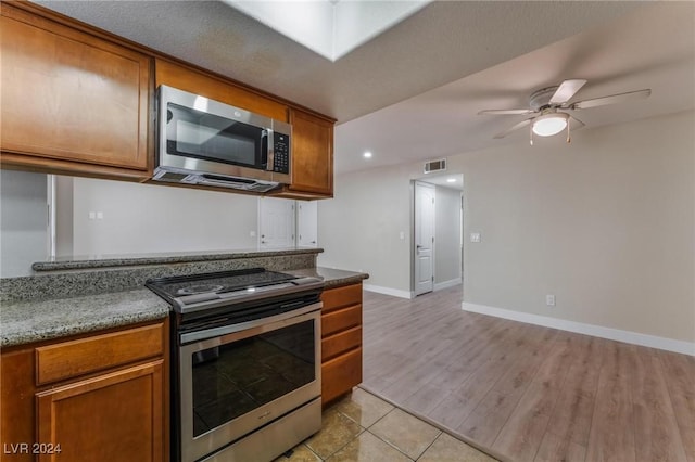 kitchen featuring ceiling fan, light hardwood / wood-style flooring, and stainless steel appliances