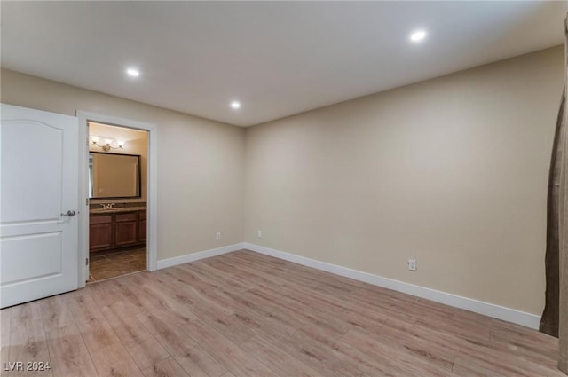 spare room with light hardwood / wood-style floors and sink