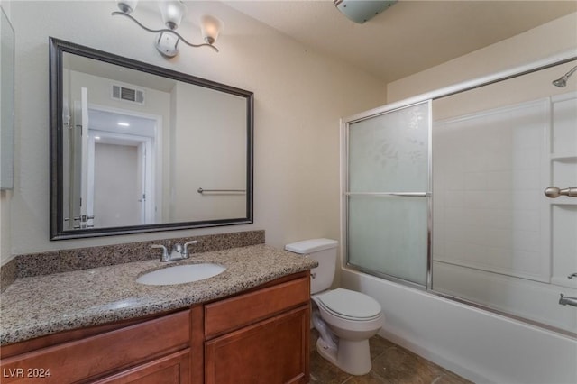 full bathroom with shower / bath combination with glass door, tile patterned floors, vanity, and toilet