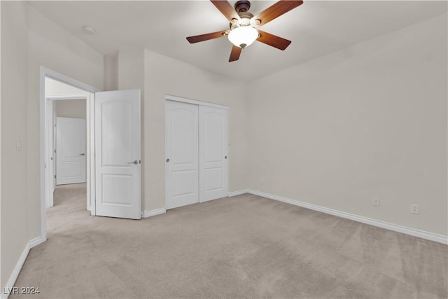 unfurnished bedroom with light carpet, a closet, and ceiling fan