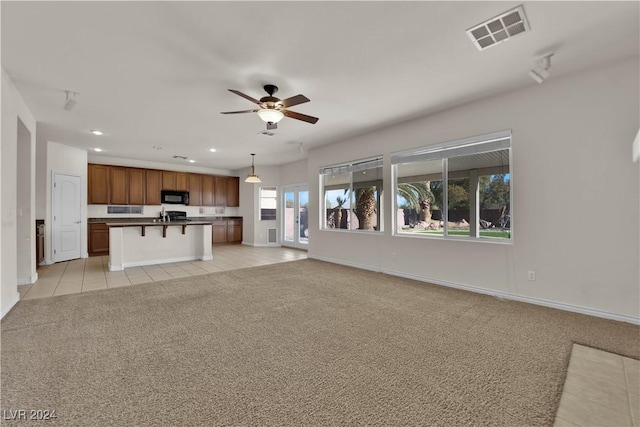 unfurnished living room featuring ceiling fan and light colored carpet