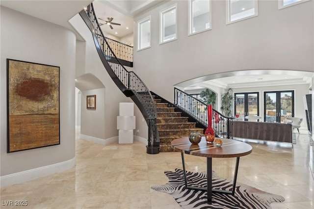 foyer entrance featuring stairway, baseboards, and arched walkways