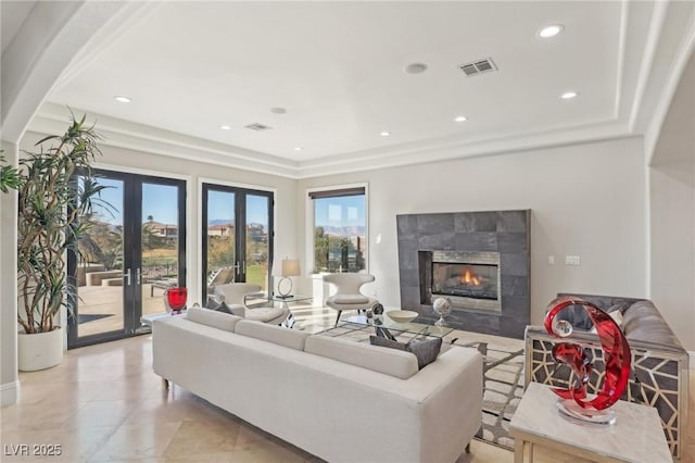 living area with visible vents, recessed lighting, french doors, and a premium fireplace