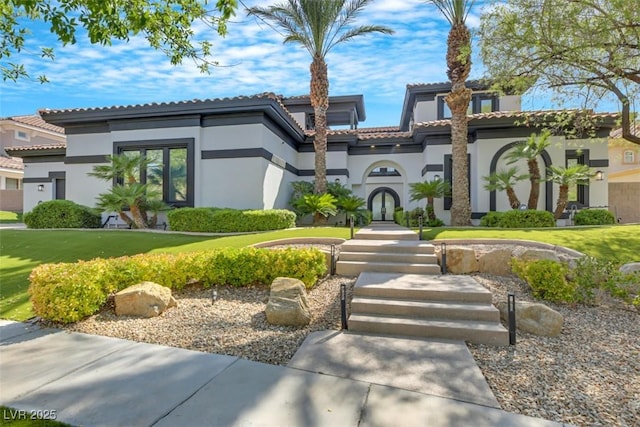 view of front of property featuring french doors, a tile roof, a front lawn, and stucco siding