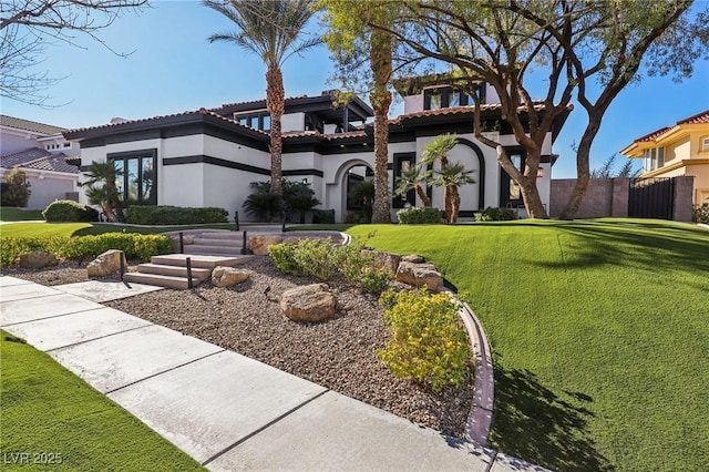 view of front of home featuring a tiled roof, stucco siding, a front lawn, and fence