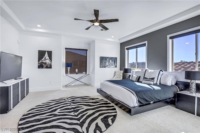 bedroom with a tray ceiling, ceiling fan, and light colored carpet