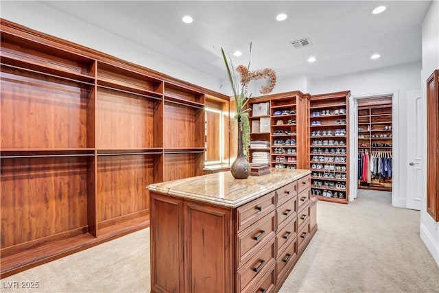 spacious closet featuring light colored carpet