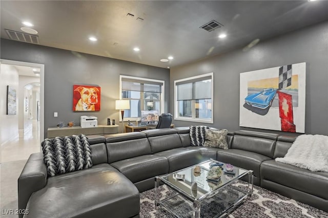 living room featuring arched walkways, visible vents, and recessed lighting