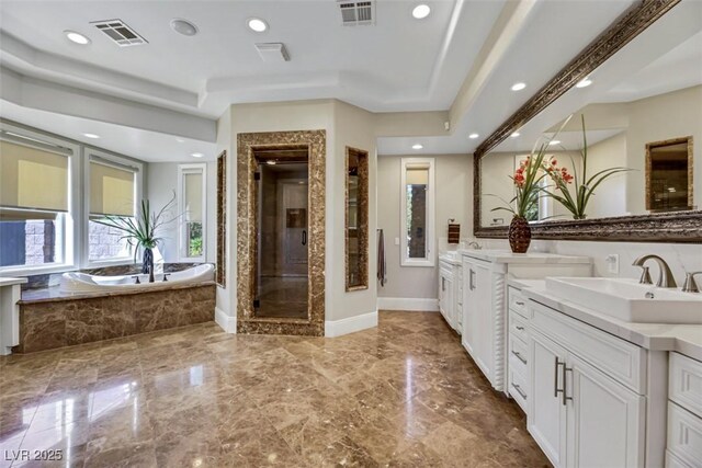 bathroom with vanity, a tray ceiling, separate shower and tub, and elevator