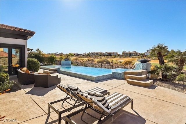 view of pool with a patio area, a hot tub, and an infinity pool