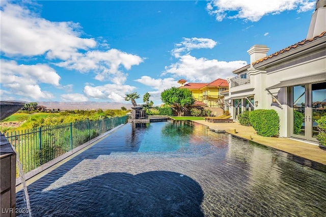 view of swimming pool with french doors and a water view