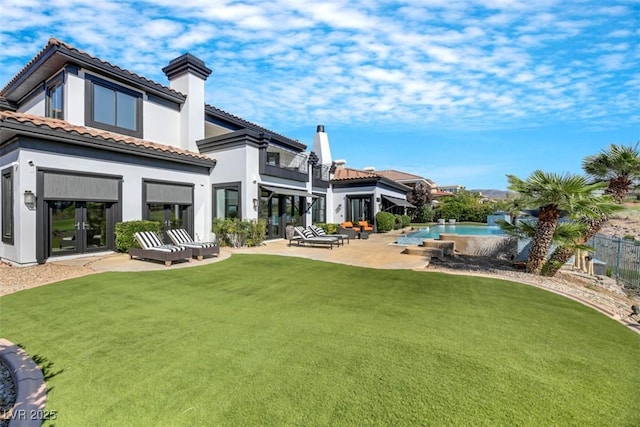 back of property with a tile roof, stucco siding, a yard, an outdoor pool, and a patio