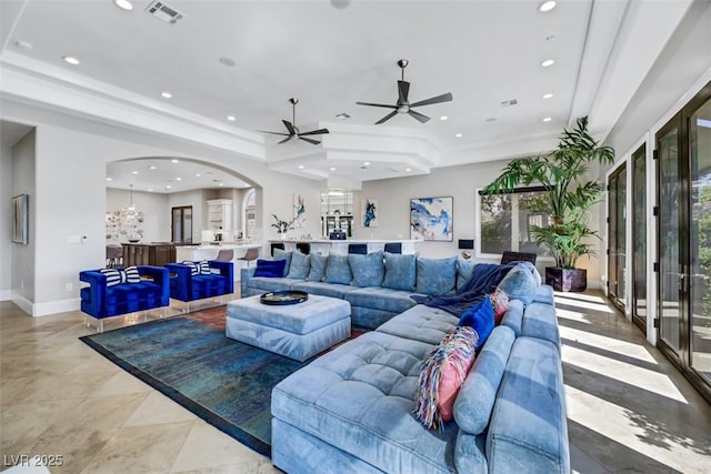 living room with visible vents, baseboards, recessed lighting, arched walkways, and a raised ceiling