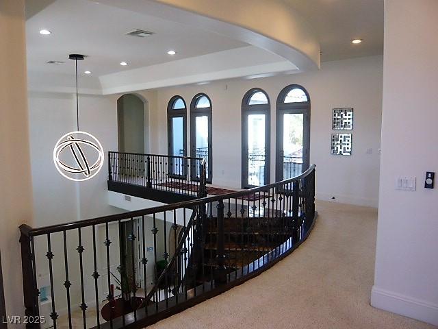 stairs featuring recessed lighting, visible vents, a raised ceiling, and carpet