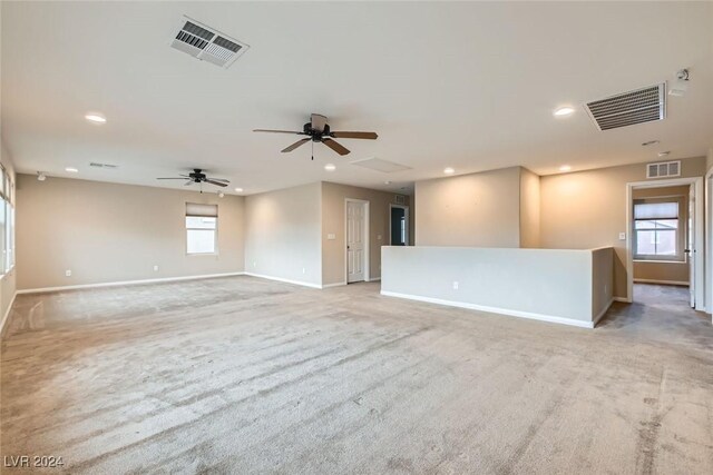 unfurnished room featuring light carpet and a healthy amount of sunlight