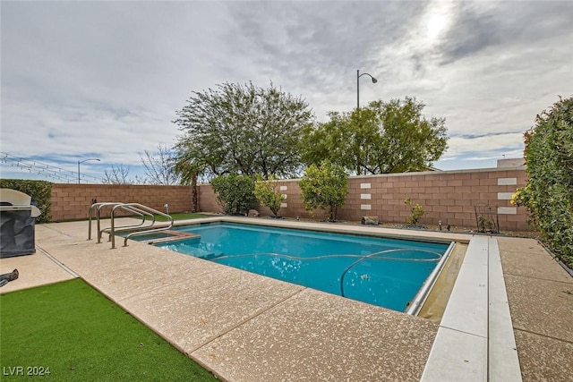 view of swimming pool with a grill and a patio